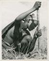 Digging for roots: /Naoka digging for a root in the grass with her digging stick (print is a cropped image)