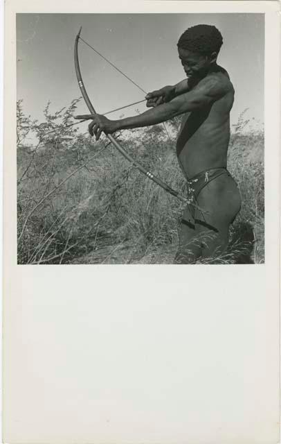 [No folder title]: "/Qui Hunter" holding a bow and arrow, showing method of holding and releasing