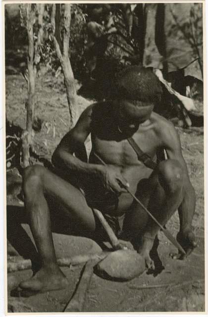 [No folder title]: "Gao Helmet" hammering and shaping an assegai blade with a piece of metal (print is a cropped image)