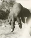 "The hunting hand signs": Person demonstrating the hunting hand signal for an unidentified animal (print is a cropped image)