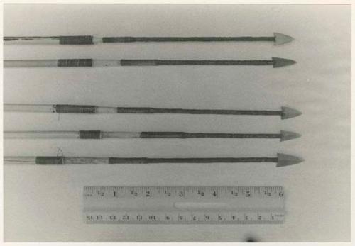 Hunting equipment: Five arrows and ruler for measurement (print is a cropped image)