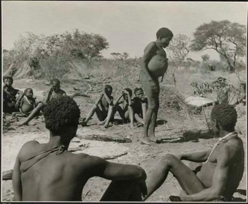 "Gao Hunchback" (leader of Band 11) standing, members of his band visiting at Gautscha sitting near him