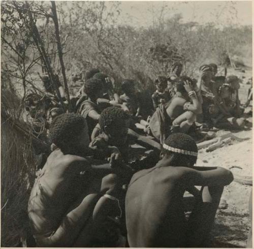 Girls seated close together; one playing a //guashi