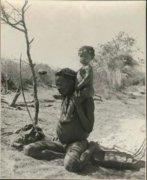 Young man of "Gao Hunchback's" band with his child on his shoulder, with a //guashi beside him