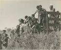 Women and children climbing down from an expedition truck, assisted by Heinrich Neumann and Ernst Westphal