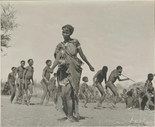 Woman dancing in the foreground, with a group of people behind