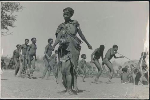 Woman dancing in the foreground, with a group of people behind