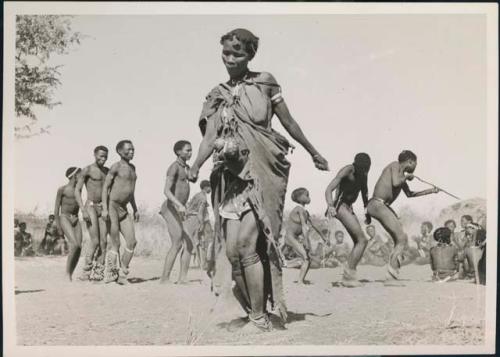 Woman dancing in the foreground, with a group of people behind