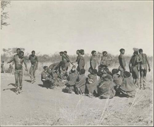 Group of Ju/'hoansi dancing; "/Gao Music" held by his hands
