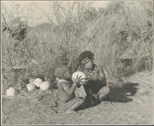 N!ai giving /Gaishay a drink from an ostrich eggshell