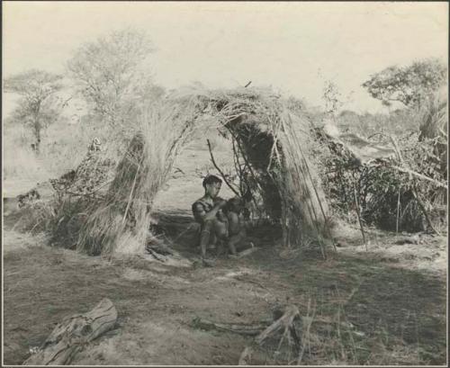 Woman sitting in a skerm nursing her child



