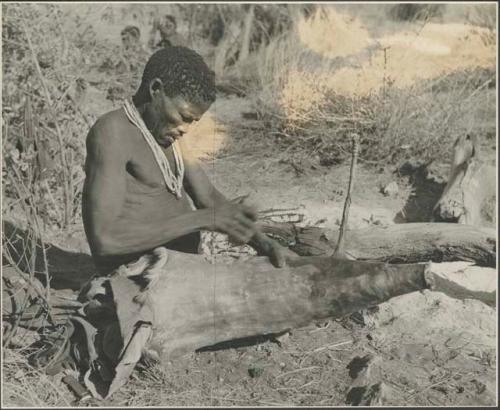 Man making a bag of the whole skin out of a wild pig