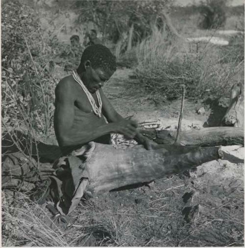 Man making a bag of the whole skin of a wild pig