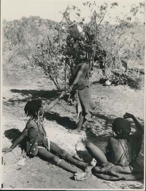 Three girls handing a cigarette to one another
