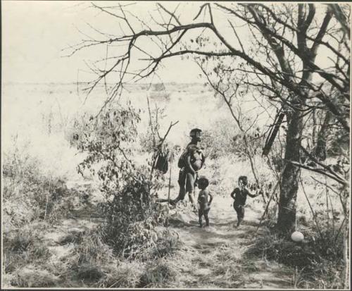 //Kushay, "Gao Helmet's" second wife, and two children standing in their living place
