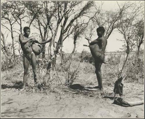 Two men standing with skin bag full of tsi over their shoulders