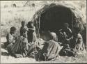 "/Qui Hunter" cooking and sitting with a group of people in front of a skerm