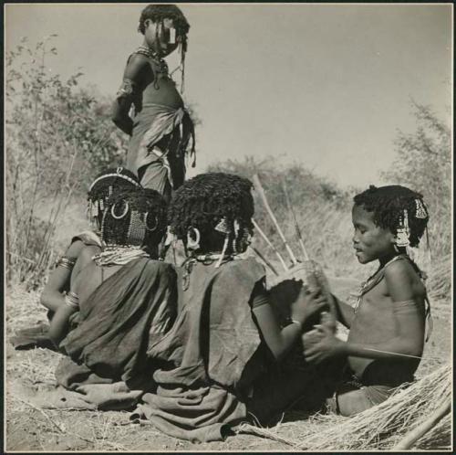 Girls seated close together, one playing a //guashi