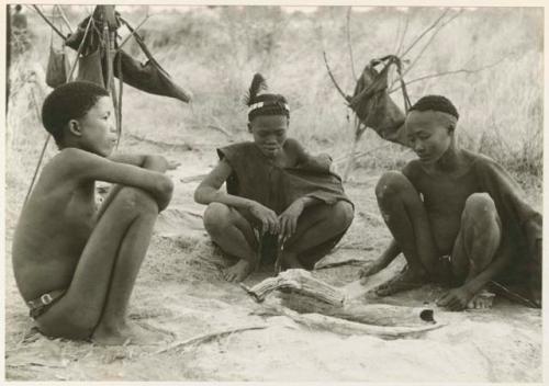 "Boys' fire": Three boys seated by a fire, including !Naishi (/Goishay's brother) (print is a cropped image)