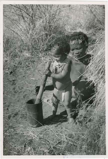 "Mortar and pestle": !Ungka (≠Toma's sister) and her daughter, Sa≠gai, who is playing with a mortar and pestle (print is a cropped image)