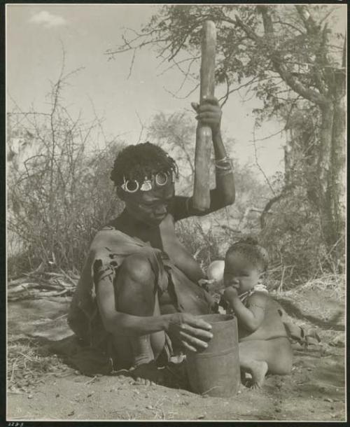 "Mortar and pestle": ≠Toma's sister pounding something with mortar and pestle, with her child sitting next to her (print is a cropped image)