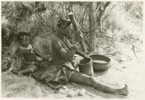 "Mortar and pestle": Di!ai, wife of Gao, pounding something in a mortar, with a child sitting behind her (print is a cropped image)