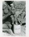 "Mortar and pestle": Person using a mortar and pestle, close-up (print is a cropped image)