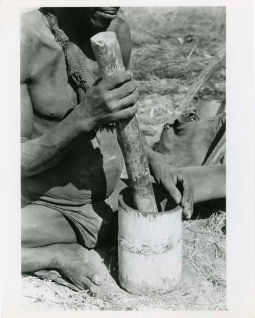 "Mortar and pestle": Person using a mortar and pestle, close-up (print is a cropped image)