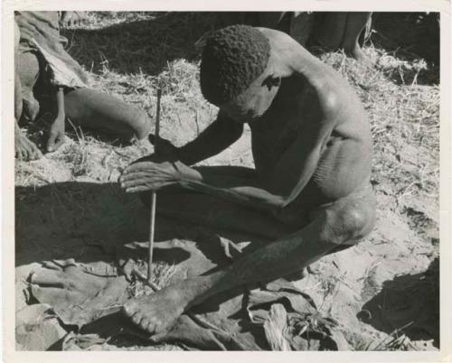 "Firemaking": Man making a fire (print is a cropped image)