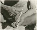 "Firemaking': Man sharpening a stick (print is a cropped image)