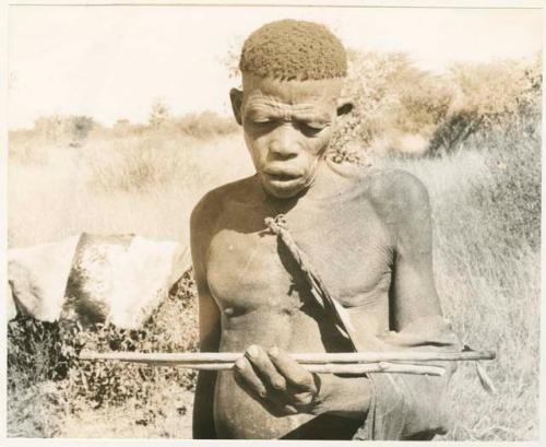 "Firemaking": Man who made the fire holding the firesticks (print is a cropped image)