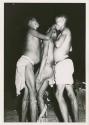 "Night dance at Tsumkwe 1957-8, some published in my [Lorna Marshall's] dance paper": Three men standing, one in trance (print is a cropped image)