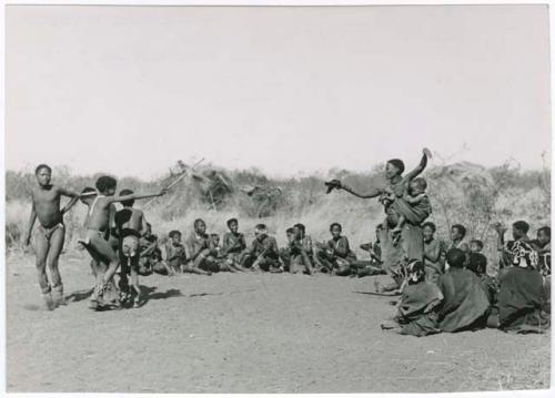 "Daytime dance at Gautscha": Two women and boys dancing, with a group of women sitting and clapping at the beginning of a dance (print is a cropped image)