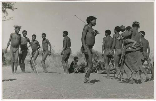 "Daytime dance at Gautscha": Group of people dancing, including a woman dancing with her baby (right) and //Ao (center) (print is a cropped image)