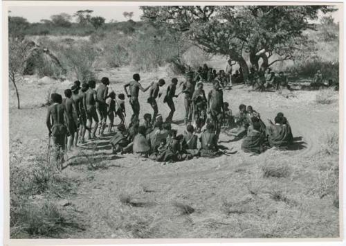 "Daytime dance at Gautscha": Woman dancing with a group of men in a circle around a group of women sitting, in an early stage of a dance (print is a cropped image)