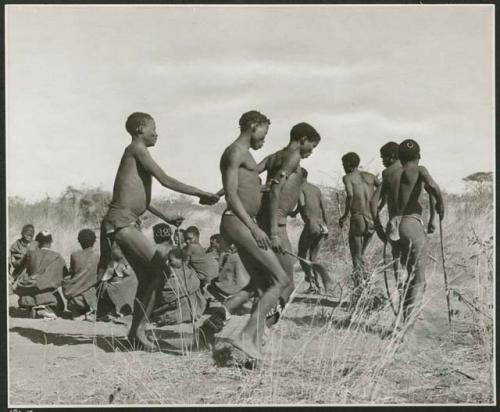 "Daytime dance at Gautscha": Men dancing, including "/Gao Music" being held by other men who also appear to be in partial trance (print is a cropped image)