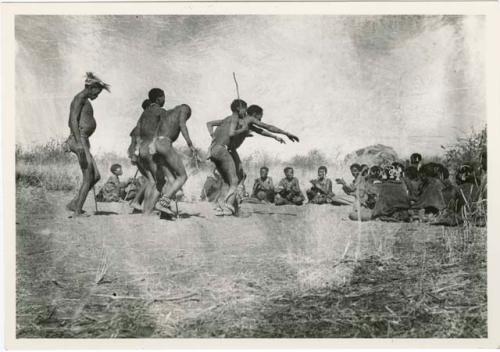 "Daytime dance at Gautscha": Men dancing through a circle of women sitting, with one man's arms outstretched (print is a cropped image)