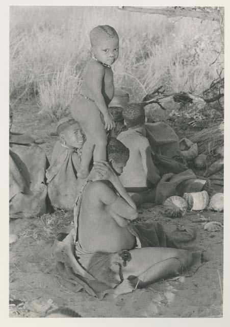 N!whakwe standing on his mother Tsekue's shoulders

