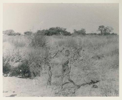 Two boys standing in grass, full figure


