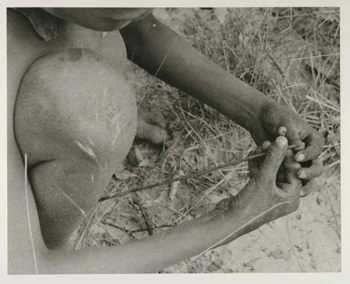 !Oukabe crouched, holding a stick in his hands, close-up



