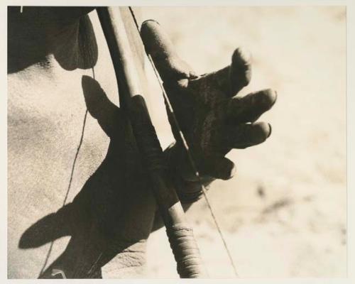 Close-up of Oukwane's left hand demonstrating how to play a musical bow


