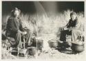 Wilhelm Camm and Philip Hameva sitting at a cooking fire at night



