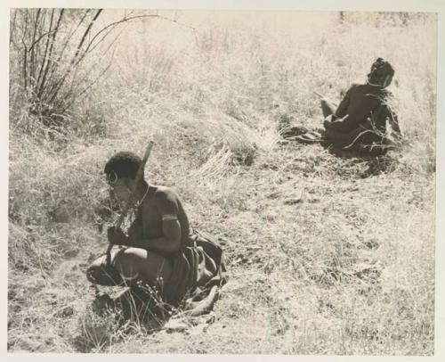 //Kushay and another woman digging, crouched in the grass



