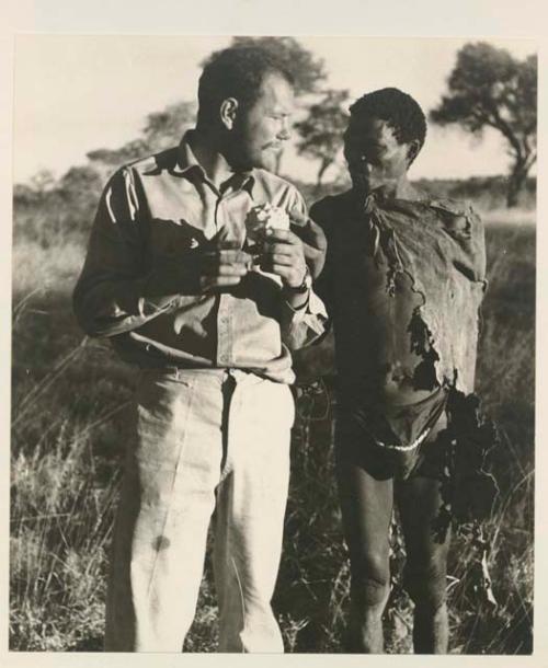 "Gao Medicine" standing and talking with William Donnellan who is holding a cucumber


