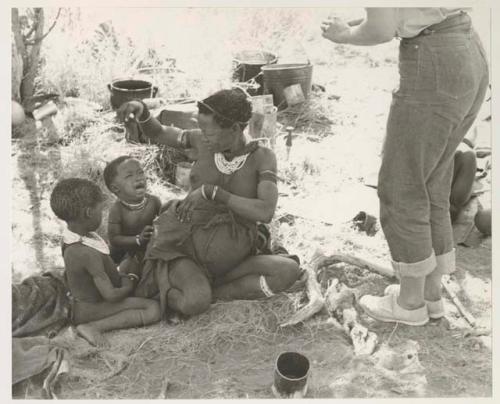 Di!ai sitting with her two youngest children, /Gaishay (left) and Debe (right), and Elizabeth Marshall Thomas' legs
