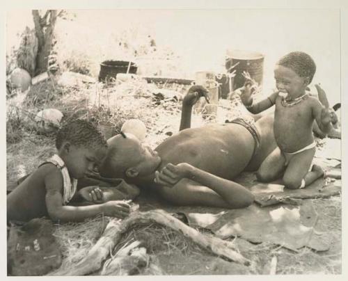 Debe kneeling beside "≠Gao Lame" eating mealies