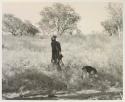 Man walking with a dog in the grass
