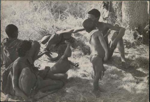 Group of people sitting, including /Naoka ("Gao Medicine's" first wife) with her granddaughter Bau and Gao Medicine, and /Gaishay standing

