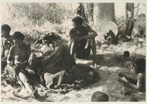 /Naoka, Di!ai and Gao sitting, and a group of children under a kaross
