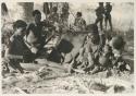 Di!ai sitting and holding Debe on her left knee, and /Naoka and "Gao Medicine" sitting to the left

